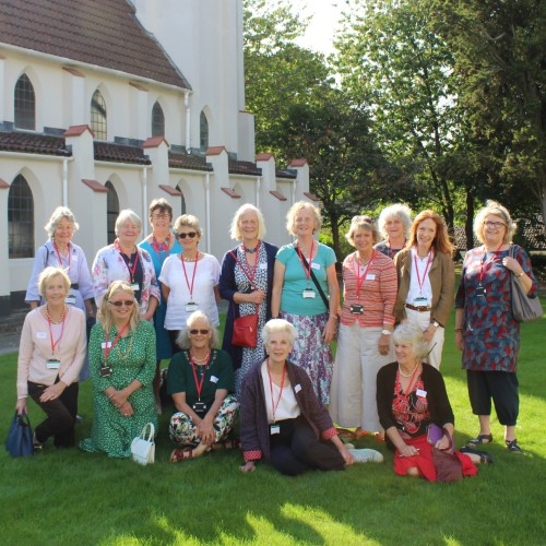 Downe House alumnae stand outside chapel smiling for a reunion